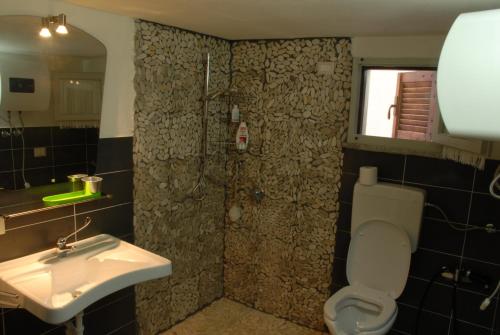 a bathroom with a sink and a toilet and a shower at Domu Noa in Torre Dei Corsari
