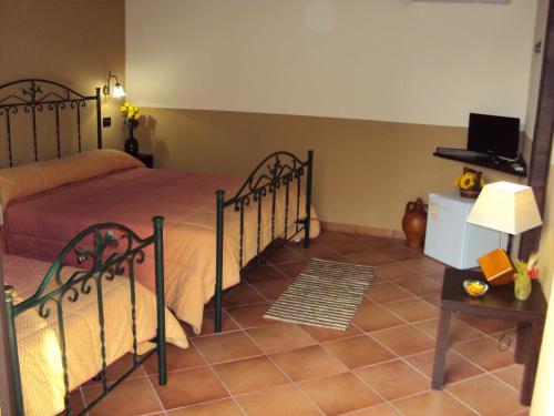 a bedroom with a bed and a table with a lamp at Agriturismo Il Pozzo Antico in Mascali