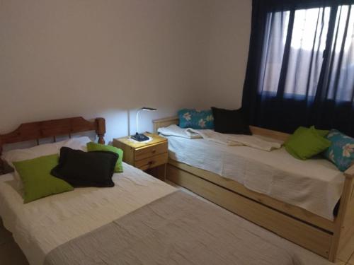 1 dormitorio con 2 camas y almohadas verdes en NUESTRO DEPARTAMENTO en Godoy Cruz