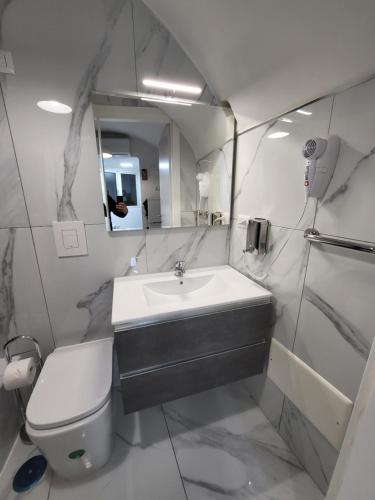 a bathroom with a sink and a toilet and a mirror at Suite SAN GENNARO in Naples
