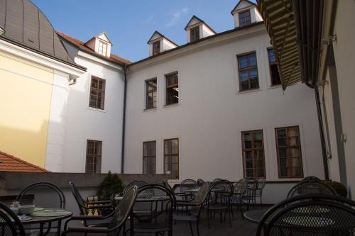 a patio with tables and chairs in front of a building at Hotel Vacek Pod Věží in Hradec Králové