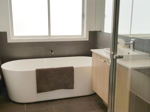 a bathroom with a white tub and a sink at ADAGIO in Point Lonsdale