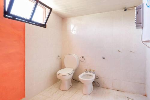 a bathroom with a toilet and a bidet at El Canadiense Hospedaje in San Rafael