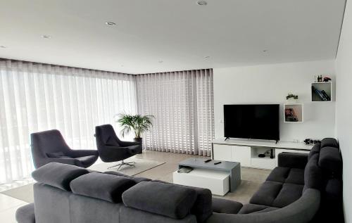sala de estar con sofá, 2 sillas y TV en Geresmarinahouse, en Gerês