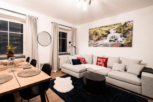 ein Wohnzimmer mit Sofa und Tisch in der Unterkunft Apartment Na Skále CLOSE TO CITY CENTER & SKI LIFT in Špindlerův Mlýn