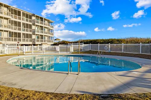 a swimming pool in front of a building at Dunescape Villas 211 in Atlantic Beach