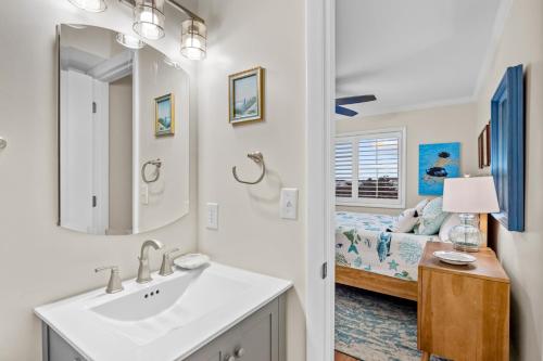 un bagno con lavandino e una camera con letto di Dunescape Villas 211 ad Atlantic Beach