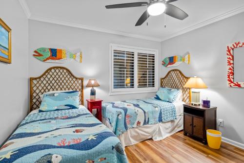een slaapkamer met 2 bedden en een plafondventilator bij Dunescape Villas 211 in Atlantic Beach