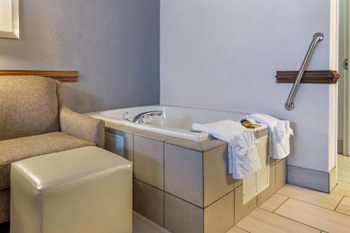 La salle de bains est pourvue d'une baignoire, d'une chaise et d'un lavabo. dans l'établissement Best Western Plus South Hill Inn, à South Hill