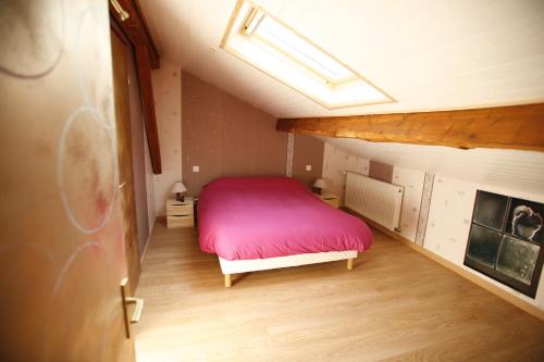 een slaapkamer met een rood bed op zolder bij soir de lune in Lorp Sentaraille
