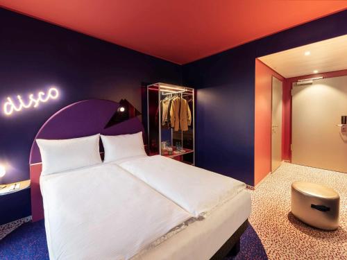 um quarto com uma cama grande e um guarda-roupa em ibis Styles Muenchen Perlach em Munique