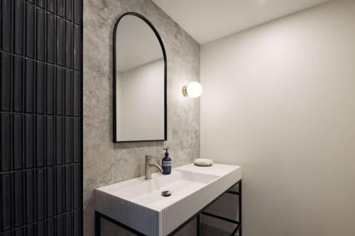 W łazience znajduje się umywalka i lustro. w obiekcie Hotel TOTTO Wollongong w mieście Wollongong
