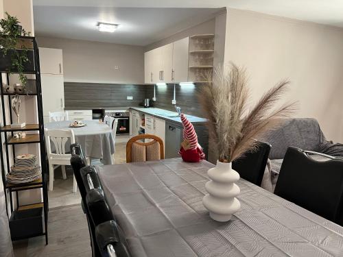 a kitchen and dining room with a table with a vase at Schöne Wohnung mit dem Garten in Jübek