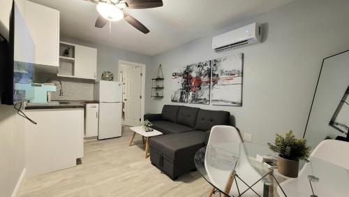 a living room with a couch and a kitchen at Barefoot mailman motel in Lantana