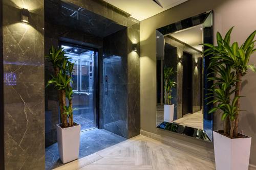 a bathroom with a large mirror and potted plants at 4 Sur Hotel in Medellín