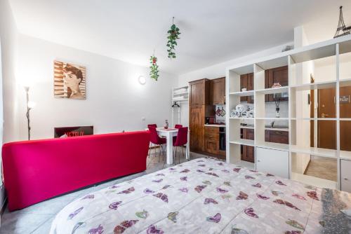 sala de estar con sofá rojo y cocina en Delizioso flat in centro storico - Free WiFi & Netflix, en Massa Lombarda