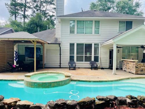 ein Haus mit einem Swimmingpool vor dem Haus in der Unterkunft ALOHA In The Woodlands! 5BD/3BA Hawaiian Oasis in Conroe