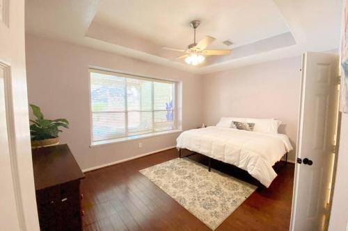 ein Schlafzimmer mit einem Bett und einem Deckenventilator in der Unterkunft ALOHA In The Woodlands! 5BD/3BA Hawaiian Oasis in Conroe