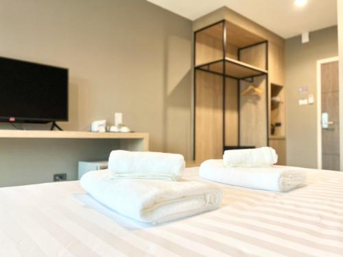 a bedroom with two white towels on a bed at S.R.SUNSHINE HOTEL in Ban Sok Dua