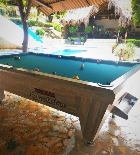 a pool table in front of a swimming pool at Hostal Villa Cata in El Zaino