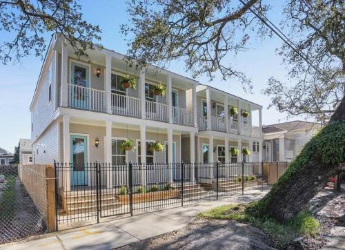 a white house with a fence in front of it at La Belle Cottage II 2queenbeds 10min to French Qtr in New Orleans