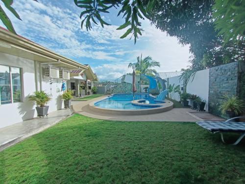 un patio trasero con piscina y parque infantil en VickyBella's FUNadise Private Resort, en Cauayan