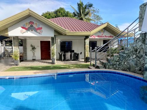 a house with a swimming pool in front of a house at VickyBella's FUNadise Private Resort in Cauayan