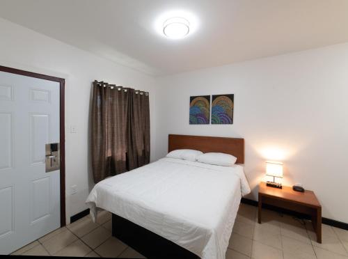 a bedroom with a bed and a table with a lamp at American Inn in Baton Rouge