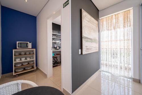 a hallway with a blue accent wall and a window at K1 RESIDENCE Taquaral in Campinas