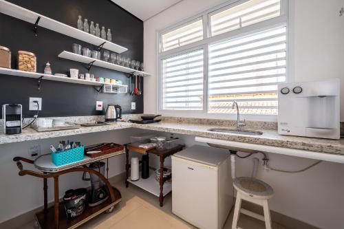 a kitchen with a counter and a sink in it at K1 RESIDENCE Taquaral in Campinas