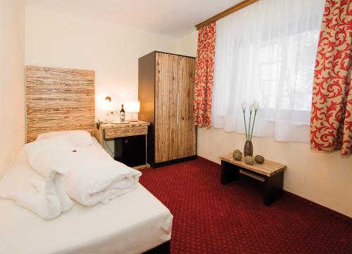 Pokój hotelowy z łóżkiem, biurkiem i oknem w obiekcie Panorama Landhaus - Joker Card included in Summer w Saalbach Hinterglemm