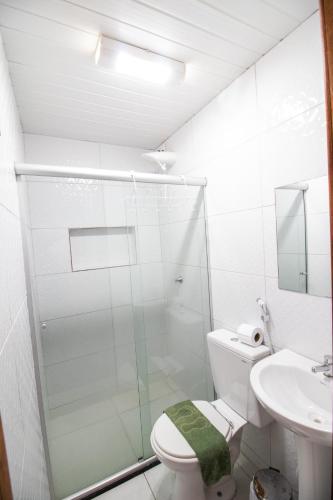 a bathroom with a shower and a toilet and a sink at Pousada Raio de Sol in Lençóis