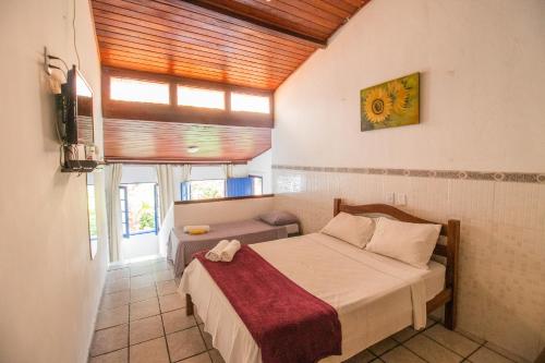 a bedroom with a bed in a room with a window at Pousada Raio de Sol in Lençóis