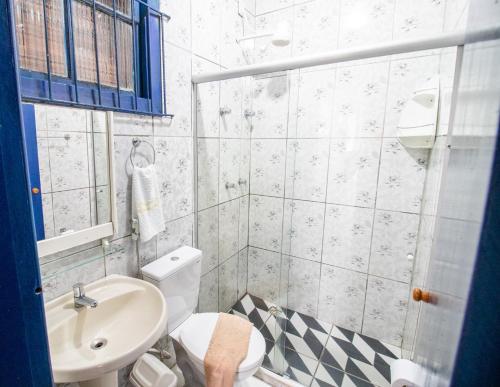 a bathroom with a white toilet and a sink at Pousada Raio de Sol in Lençóis