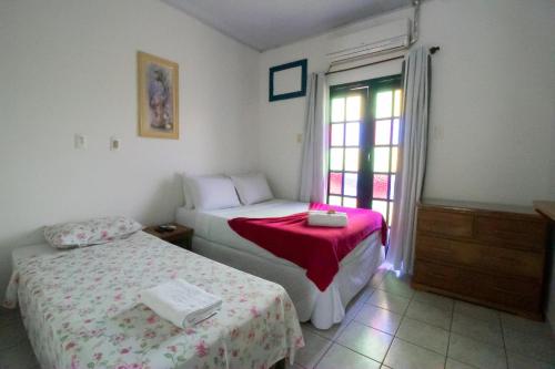 a bedroom with two beds and a window at Pousada Raio de Sol in Lençóis
