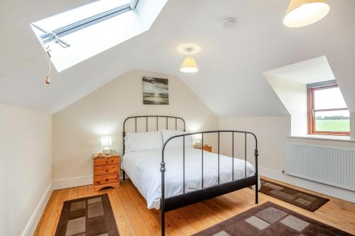 a bedroom with a bed and a window at Bwythyn-y-Wennol in Abersoch