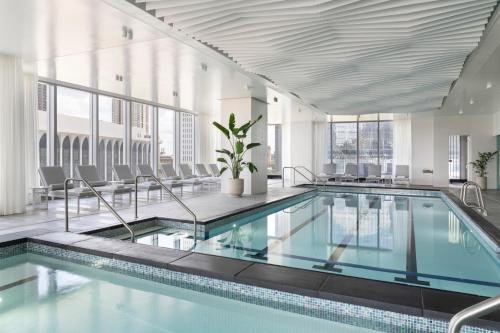 - une piscine dans un grand bâtiment avec des chaises dans l'établissement Four Seasons Hotel Minneapolis, à Minneapolis