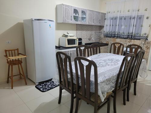 Una cocina con mesa y sillas y un refrigerador. en Casa para alugar, en Foz do Iguaçu