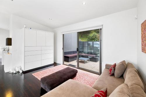 a living room with a couch and a large window at Summerhills House - BYO Linen in Lorne