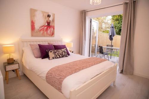 a bedroom with a large bed and a balcony at Panorama House, Delightful 2-Bedroom Flat 1, Oxford in Oxford
