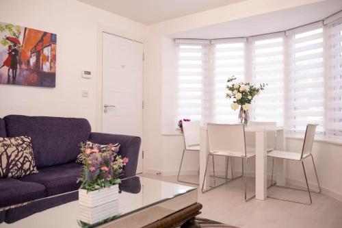 sala de estar con sofá y mesa con flores en Panorama House, Delightful 2-Bedroom Flat 1, Oxford, en Kidlington