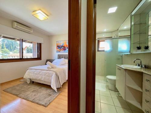 1 dormitorio con 1 cama y baño en Apartamentos Jardim da Serra CENTRO by Achei Gramado, en Gramado