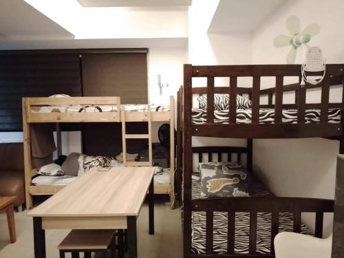 a room with two bunk beds and a table at Comfy Bunkbeds at BSA in Manila