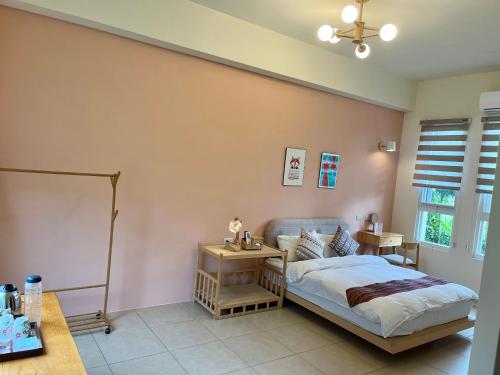 a bedroom with a bed and a table and a window at Mei Jung B&B in Zhixue