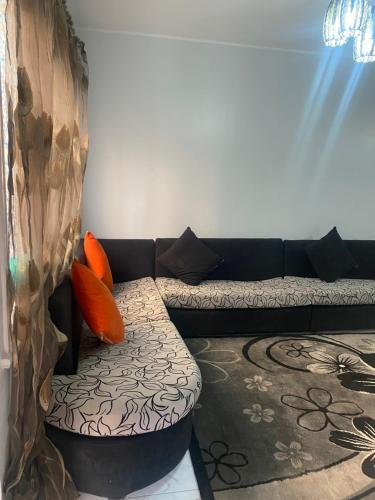 開羅的住宿－A lovely apartment for rent，客厅配有带橙色枕头的黑色沙发