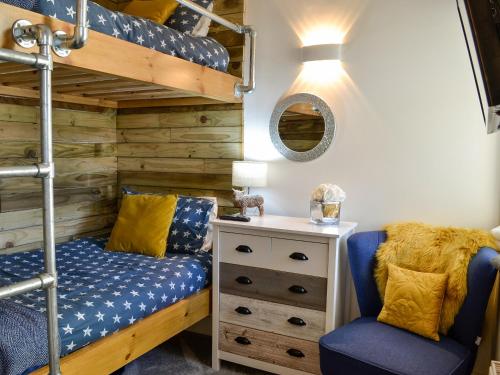 The Coop في قلعة دوغلاس: غرفة نوم مع سرير بطابقين وكرسي أزرق