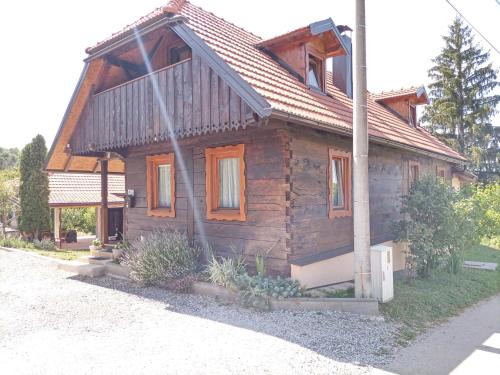 ein Holzhaus mit einem Metalldach auf einer Straße in der Unterkunft Family friendly house with a swimming pool Mihalic Selo, Karlovac - 20284 in Duga Resa