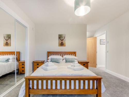 1 dormitorio con 1 cama grande y espejo en Iora Rua-uk40006 en Gartmore