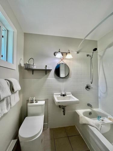 a bathroom with a toilet and a sink and a tub at Barefoot Villas and Retreat in Christina