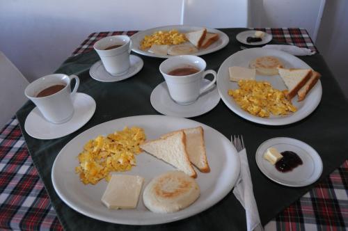 a table with plates of breakfast foods and cups of coffee at Hotel Montecarlo Beach in Tolú